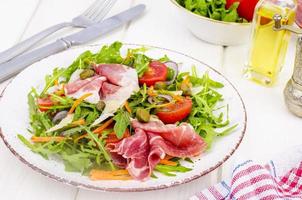 verse huisgemaakte salade met rucola, jamon, rucola, tomaten, parmezaanse kaas. foto