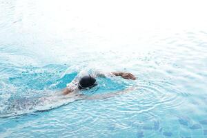 Aziatisch mannen beoefenen zwemmen en voorbereidingen treffen naar Speel water polo en uitrekken en resting voor water sport. foto