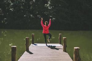 Aziatische vrouwen ontspannen in de vakantie. spelen als yoga. op de bamboebrug naast het meer in de mist bij pang ung, mae hong son provincie, thailand. foto