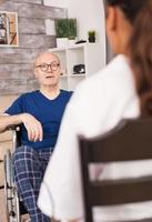 oude man praat met verpleegster foto