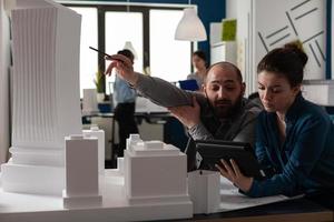 team van bouwarchitecten werken op tablet op kantoor foto
