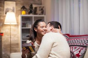 jonge vrouw geeft een dikke knuffel aan haar man op eerste kerstdag