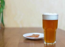 bier in een glas op tafel en een bord met vis foto