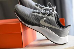 Nike hardloopschoenen, nike air zoom pegasus 37 grijs-witte heren hardloopschoenen op doos in de winkel foto