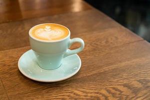 hete latte koffiekopje op tafel foto