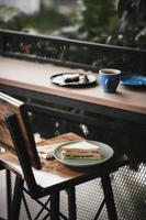 sandwich en warme koffie op houten bar foto