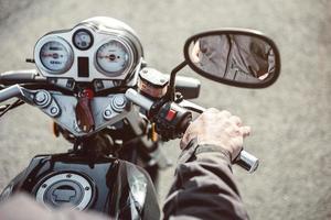 senior man hand stuur motorfiets op de weg foto