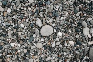 grindpatroon van gekleurde stenen. abstracte natuur kiezelstenen achtergrond. stenen achtergrond. zee kiezels strand. bovenaanzicht. foto