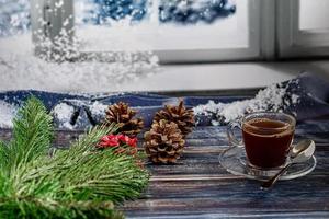een kopje aromatische koffie met bruine suiker, kerstversiering, takken van een kerstboom. vakantie concept nieuwjaar. op een houten achtergrond. foto