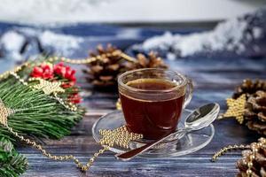 een kopje aromatische koffie met bruine suiker, kerstversiering, takken van een kerstboom. vakantie concept nieuwjaar. op een houten achtergrond. foto