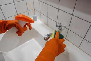 vrouw hulp in de huishouding Aziatisch of werkster hand- schoonmaak badkamer foto