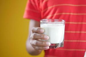 kind jongen hand houdt een glas melk vast foto