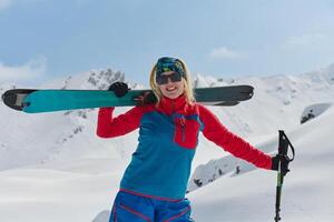 een professioneel vrouw skiër verheugt zich na met succes beklimming de besneeuwd pieken van de Alpen foto