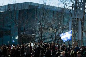 Montreal, Canada, 2 april 2015 - iemand die de vlag van de provincie Quebec vasthoudt in de menigte foto