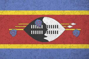 Swaziland vlag afgebeeld in helder verf kleuren Aan oud Verlichting bepleistering muur. getextureerde banier Aan ruw achtergrond foto