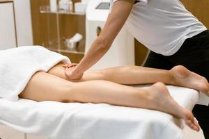 vrouw van middelbare leeftijd met een beenmassage in een schoonheidssalon. foto