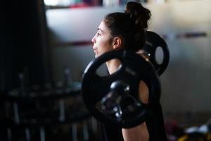 atletische vrouw in sportschool gewichtheffen in de sportschool foto