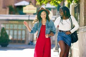 twee vrouwen lopen samen op straat. multi-etnische vrienden. foto