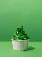 kerstboomvormige cupcakes op groene achtergrond foto