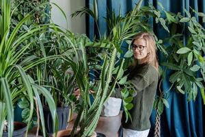 jonge vrouw die thuis voor de planten zorgt foto