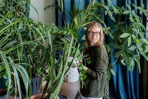 jonge vrouw die thuis voor de planten zorgt foto