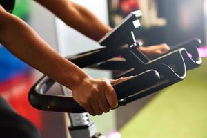 vrouw in een sportschool doet spinning of cyclo indoor met slimme horloge foto