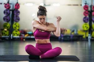 jonge vrouw doet rekoefeningen op een yogamat foto