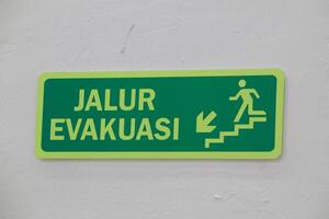 matram, Indonesië, 13 juni 2024. evacuatie route teken met wit muur achtergrond foto