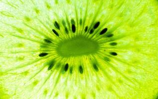 verse kiwi fruit plakjes achtergrond. verzameling van fruit- en groentepatroonachtergronden. natuurlijke groene achtergrond in volledig frame. een close up van kiwi textuur. foto