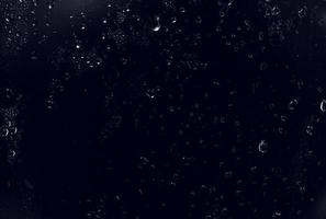 waterdruppels op zwarte achtergrond. abstracte dauwwaterdruppels op een vensterglas voor een foto-overlay-effect of een fris effect op het mockup van dranken. macro-opname van de gedetailleerde regendruppel. foto