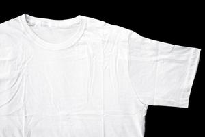 details van witte t-shirtstof voor badge-mockups. effen t-shirt met zwarte achtergrond voor ontwerpvoorbeeld. foto