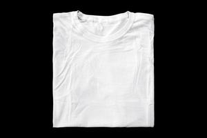 witte t-shirts gevouwen voor badge-mockups. effen t-shirt met zwarte achtergrond voor ontwerpvoorbeeld. foto