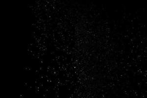 de witte deeltjes op een zwarte achtergrond die een sneeuwval vertegenwoordigen. sneeuw overlay beelden voor het geven van een ijskoud of winter effect aan de videopresentatie. foto