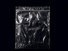 een transparante plastic zak geïsoleerd op zwarte achtergrond. leeg of leeg plastic voor mockup en sjabloon. lay-out voor advertentie of promotie. foto