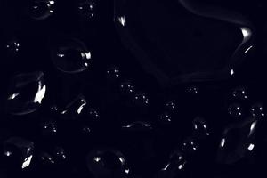 waterdruppels op zwarte achtergrond. abstracte dauwwaterdruppels op een vensterglas voor een foto-overlay-effect of een fris effect op het mockup van dranken. macro-opname van de gedetailleerde regendruppel. foto