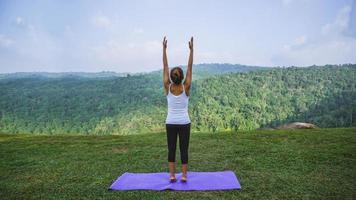 Aziatische vrouwen ontspannen in de vakantie. spelen als yoga. op de berg rots klif. aard van bergbossen in thailand. jonge vrouw die yoga beoefent in de natuur vrouwelijk geluk. yoga beoefenen foto