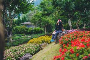 vrouw reizen natuur in de bloementuin. ontspan zittend op rotsen en lees boeken midden in de natuur in het nationale park doi inthanon. foto