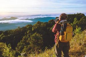 de jonge vrouw reist om foto's te maken van de zeemist op de berg. reizen ontspannen. natuurlijk tintje platteland. in chiangmai in thailand foto