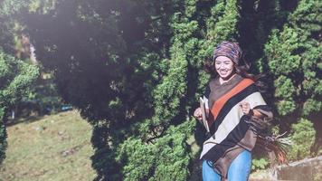 jonge vrouw ontspannen in de vakantie. reis door de natuur en schrijf een briefje blij om de schoonheid van het dennenblad te zien. natuur studie. foto