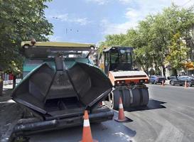 zware asfaltbetonmolen en wegtrillende rolafdichting klaar voor reparatiewegen in een moderne stad foto