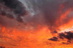 schitterende oranje zonsondergang en zonsopgang mooi boven grijze wolken met fel oranje zon op een koele lenteavond. foto