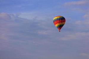 vlucht van een prachtige veelkleurige en bonte ballon in de blauwe lucht. foto