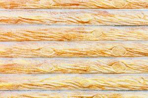 de textuur van de betonnen muur onder de stilering van een houten hek met horizontale stammen. foto