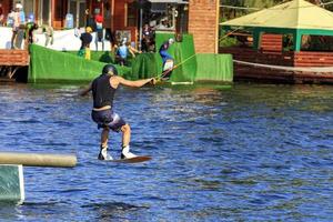 een wakeboarder snelt met hoge snelheid door het water en overwint verschillende obstakels.