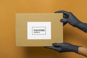 medisch begrip. covid-19 vaccin, vaccindoos. vaccinverpakking op gekleurde achtergrond foto