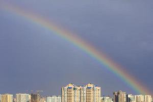 regenboog in de lucht boven de stad na een onweersbui. foto