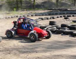 race van een tiener op een kinderbuggy langs de zandbaan foto