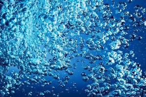 blauwe transparante watergolf splash abstract met waterbellen op blauw. foto