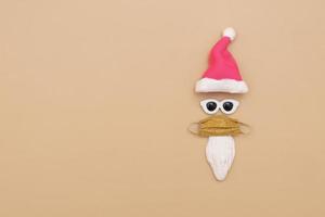 minimalistische abstracte kerstman met een bril en medisch masker op een beige achtergrond