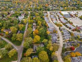 luchtfoto van woonwijk in Northfield, il. veel bomen beginnen herfstkleuren te krijgen. grote appartementencomplexen en woonhuizen. kronkelende, met bomen omzoomde straten. foto